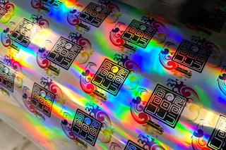 ホログラムのシートにプリントしたオリジナルステッカー。虹色に光っている